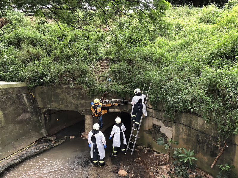 台中市西屯區工業區十六路一處大排水溝內20日有民眾發現一名男子倒臥,消防人員到場救援發現男子已明顯死亡,隨即將遺體吊掛至地面安全處,後續交由轄區警方處理;由於死者身上沒有證明文件,將進一步釐清死者身分及死因。(民眾提供)中央社記者郝雪卿傳真 111年7月20日