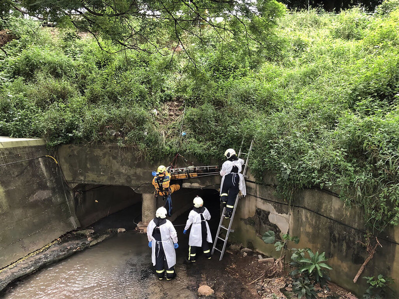 台中市西屯區工業區十六路一處大排水溝內20日有民眾發現一名男子倒臥，消防人員到場救援發現男子已明顯死亡，隨即將遺體吊掛至地面安全處，後續交由轄區警方處理；由於死者身上沒有證明文件，將進一步釐清死者身分及死因。（民眾提供）中央社記者郝雪卿傳真  111年7月20日