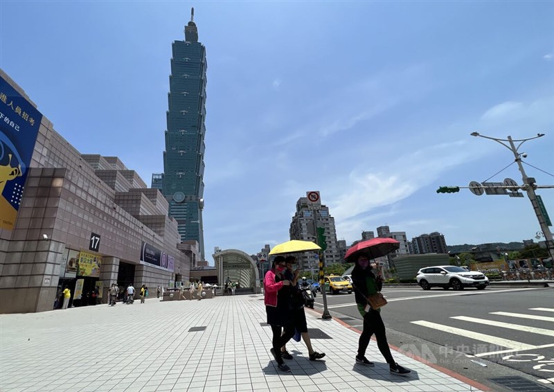 圖為台北市信義區街頭民眾撐傘遮擋毒辣陽光。（中央社檔案照片）