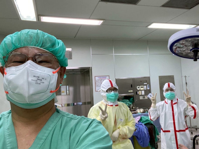嘉義市一名體重125公斤孕婦原定7月中旬剖腹生產,住院前篩檢確診COVID-19,居隔第4天陣痛,於19日剖腹產下女嬰,母女均安。左為手術的衛生福利部嘉義醫院院長黃元德。(部立嘉義醫院提供)中央社記者黃國芳傳真 111年7月21日