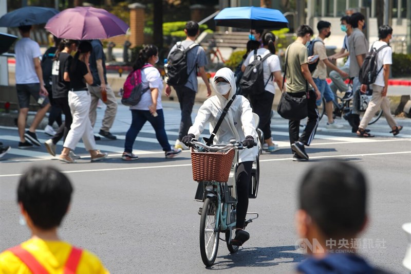 中央氣象局22日發布18縣市高溫燈號資訊，台北市中正區午後氣溫突破攝氏38度。圖為外出騎士穿著外套防曬。中央社記者王騰毅攝 111年7月22日