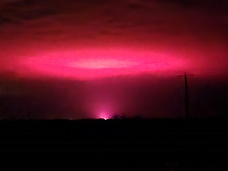 澳洲一名婦女拍下天空出現粉紅光的景象，以為災難降臨，事後才知是大麻種植場的紅光。（圖取自facebook.com/tammy.szumowski）