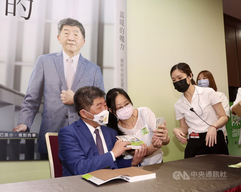 民進黨台北市長參選人陳時中(左)24日在台北舉行「溫暖的魄力:陳時中的從醫初心」新書發表會,民眾排隊等待陳時中在新書上簽名並合影。中央社記者張皓安攝 111年7月24日