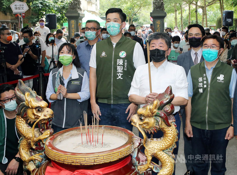 民進黨台北市長參選人陳時中（前右2）25日起在北市舉行26場「阿中與你相見歡」見面會活動，首場在大安區下內埔福安宮登場，民進黨議員參選人陳聖文（前右3）等人到場，一入場先上香參拜。中央社記者郭日曉攝  111年7月25日