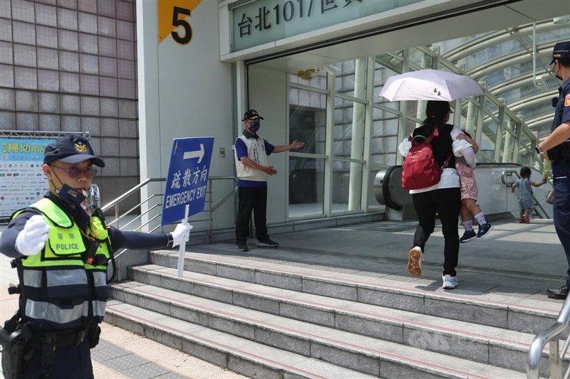 台北市信義商圈在警報發布後,由警察引導行人至捷運站避難。中央社記者吳家昇攝 111年7月25日