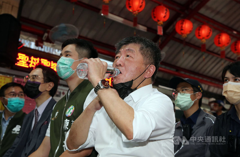 民進黨台北市長參選人陳時中（前中）25日起到8月7日將舉辦26場「阿中與你相見歡」見面會，首場在台北市大安區下內埔福安宮登場，到場支持的民眾一路排到宮廟外，陳時中利用空檔補充水分。中央社記者郭日曉攝  111年7月25日