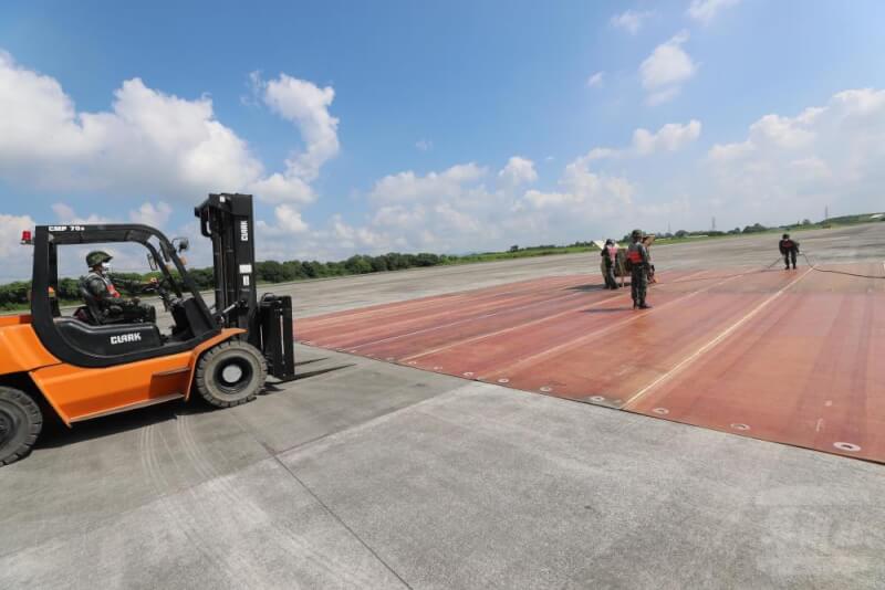 搶修小組先後進行彈坑勘測,並出動各型機具完成受損跑道填補;隨後,實施面蓆展開、結合、拖曳及跑滑道鋪設等作業,在最短時間內搶修完畢,提供戰機起降。(軍聞社提供)