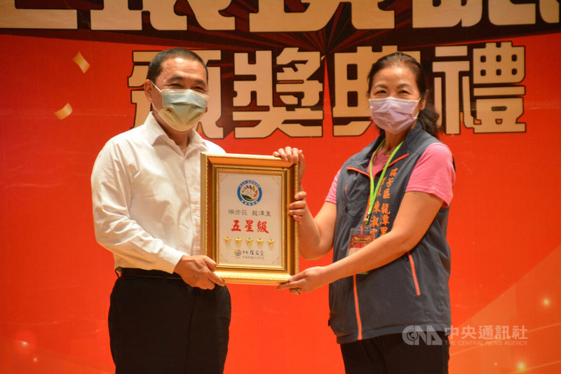 新北市長侯友宜(左)26日頒獎表揚環境五星級認證的瑞芳區龍潭里里長陳淑霞(右),該里黃金資收站不但可做環保又照顧到里民生活,成為里民相聚的熱門地點。中央社記者黃旭昇新北攝 111年7月26日