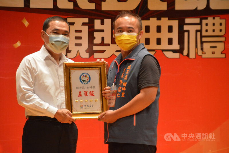 新北市長侯友宜(左)26日頒獎表揚環境五星級認證的瑞芳區柑坪里里長許銘仁(右),肯定綠美化讓環境永續。中央社記者黃旭昇新北攝 111年7月26日