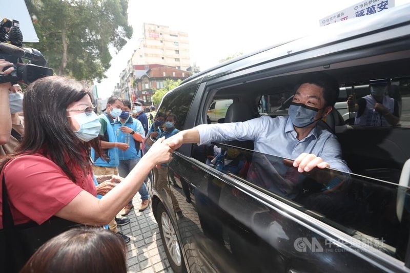 國民黨台北市長參選人蔣萬安（右）27日上午到龍山寺參拜，離開前與支持者握手致意。中央社記者吳家昇攝  111年7月27日