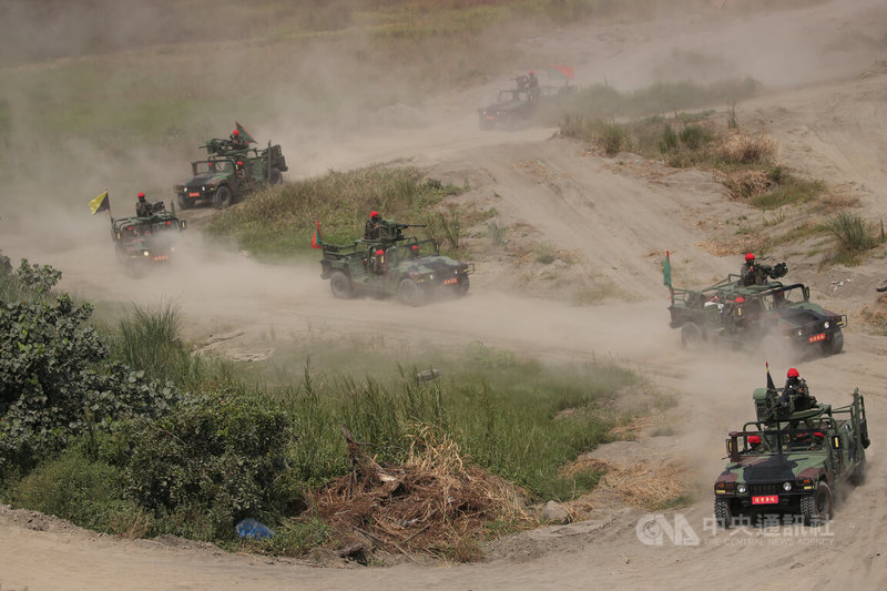 國軍漢光38號演習27日上午在新北八里地區執行「聯合反登陸作戰」操演,異地同時於新北市淡水河口、八里海灘及台北港實施聯合作戰演練,圖為扮演紅軍的部隊模擬敵軍進攻,悍馬車在海灘上奔馳。中央社記者趙世勳攝 111年7月27日