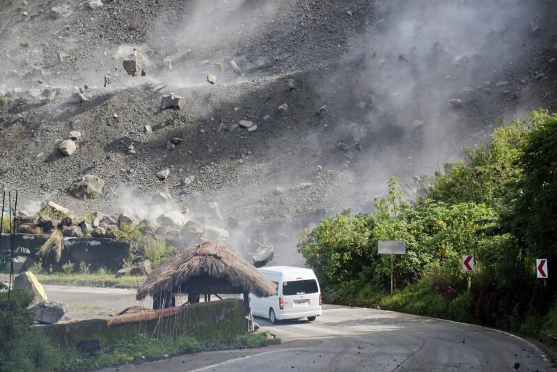 圖為27日地震發生時，一輛行駛中的車輛遇上山區巨石崩落。（美聯社）