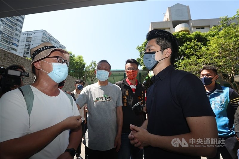 國民黨台北市長參選人蔣萬安(前右)29日應無黨籍台北市議員林瑞圖(後左,灰衣者)邀請,到北投區會勘「關渡國中興建籃球場因日照影響鄰房視力嚴重受損案」,蔣萬安聆聽居民陳情。中央社記者吳家昇攝 111年7月29日