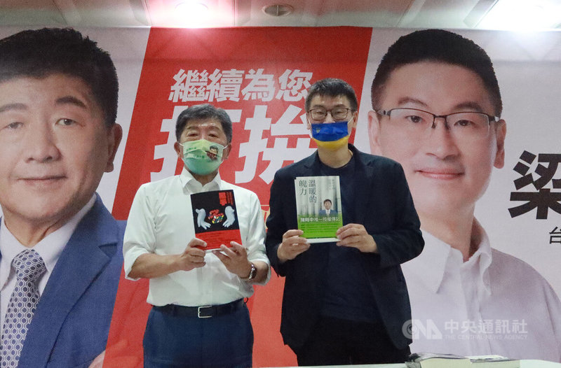 民進黨台北市長參選人陳時中（左）29日晚間與爭取連任的同黨台北市議員梁文傑（右）相見歡，並致贈新書，梁文傑也回贈翻譯著作。中央社記者蕭博文攝 111年7月29日