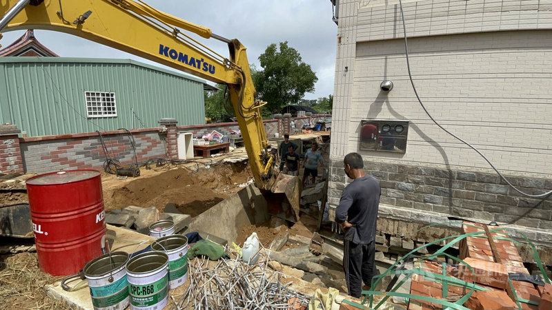 黃男透過網路從台灣找來樓房遷移公司,業者先將房屋地基下方砂土清出,墊上枕木和充當滾輪的鋼管,再用千斤頂從旁邊慢慢推移。中央社記者黃慧敏攝 111年7月29日