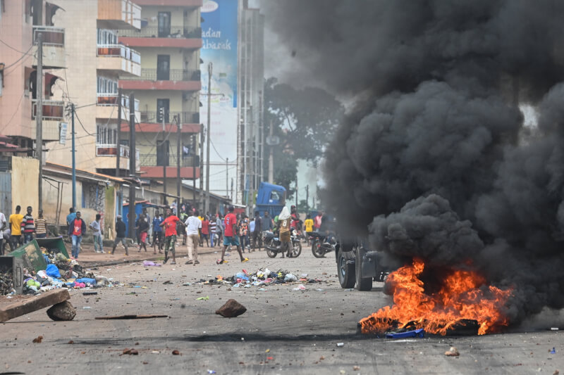 幾內亞示威民眾28日在康納克立街頭抗議，封鎖道路並投擲石塊。（法新社）