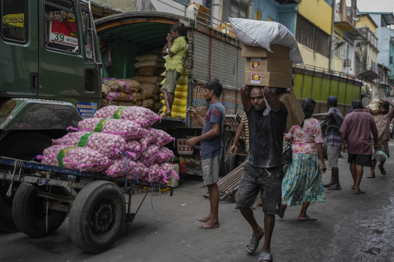 斯里蘭卡中央銀行總裁威拉辛格18日表示，國內今年經濟萎縮幅度恐會超過8.0%。圖為7月底斯里蘭卡首都可倫坡民眾搬運進口食品。（美聯社）