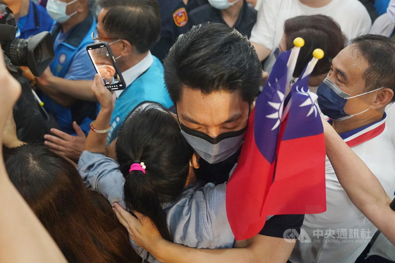 國民黨台北市長參選人蔣萬安(中)31日在百齡高中出席士林區後援會成立大會,進場時擁抱女性支持者。中央社記者徐肇昌攝 111年7月31日