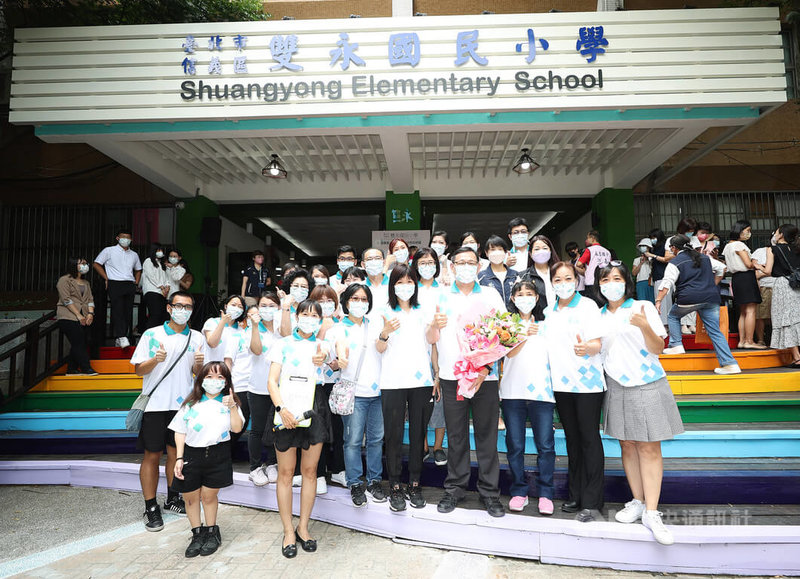 僅一牆之隔的台北市信義區永春國小與永吉國小配合市府推動市有建物及用地整合運用教育導向的都市發展(EOD)計畫,111學年度正式合併成立為雙永國民小學。雙永國小首任校長、也是前永吉國小校長楊政修(拿花者)與新行政團隊合影留念。中央社記者張新偉攝 111年8月1日