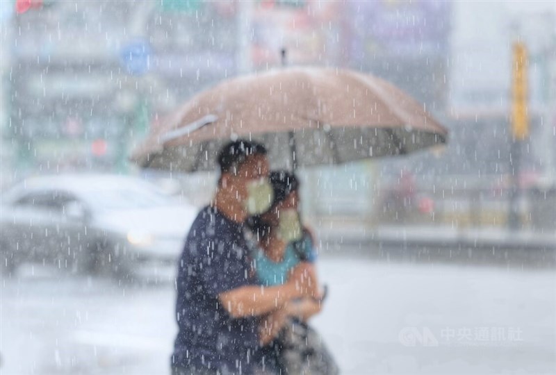 圖為台北市古亭街頭民眾在大雨中撐傘前行。中央社記者王飛華攝 111年8月2日