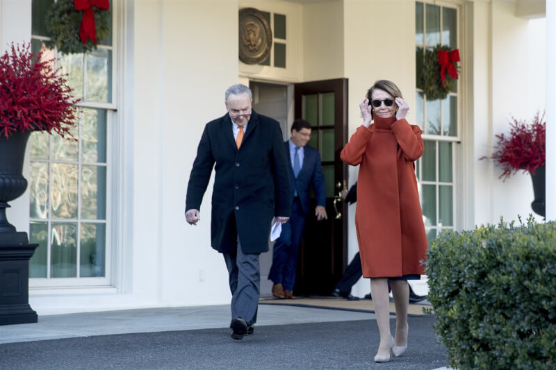 美國聯邦眾議院議長裴洛西（右）、時任參議院少數黨領袖舒默（左）2018年和川普會談結束後，裴洛西穿著一襲紅色外套，戴著太陽眼鏡步出白宮，顯得威風無比。（美聯社）
