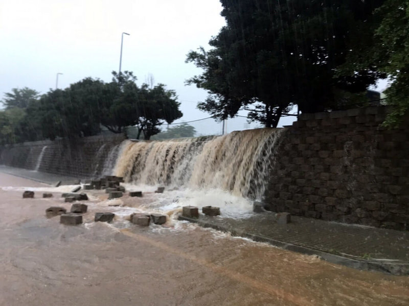 嘉義市4日下午局部強降雨,且雨勢持續不斷,造成多處低窪地區積淹水,啟明路停車場發生邊坡滑落情形,水勢猶如水瀑,消防局調派人力警戒。(民眾提供)中央社記者黃國芳傳真 111年8月4日