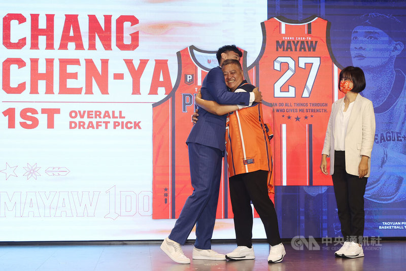台灣職籃P. LEAGUE+桃園領航猿在台北舉辦2022新秀加盟記者會,在首輪第1順位被領航猿選中的張鎮衙(左),4日在父母見證下,正式加盟球隊,他為爸爸穿上球團推出的「MAYAW IDO紀念球衣」並擁抱致意。中央社記者張新偉攝 111年8月4日