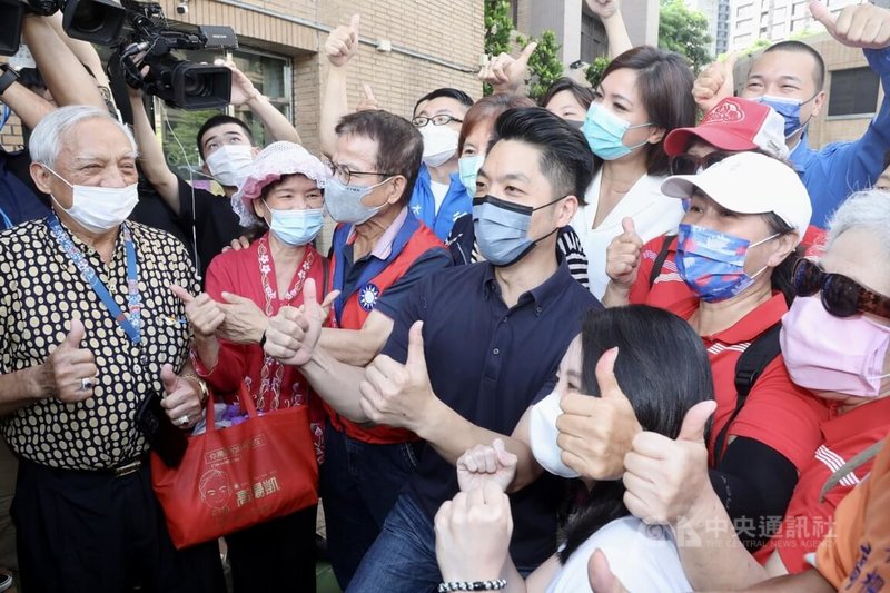 國民黨台北市長參選人蔣萬安(中,藍衣者)4日在台北出席111年社區治安營造研習觀摩會議,與支持者合影。中央社記者張皓安攝 111年8月4日