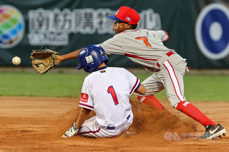 第6屆U12世界盃少棒錦標賽超級循環賽複賽4日登場,台灣隊首戰面對多明尼加,最終以16比1提前4局扣倒對手。圖為台灣隊吳聖智(左)比賽中一度以滑壘方式搶攻,成功上壘。中央社記者鄭清元攝 111年8月4日