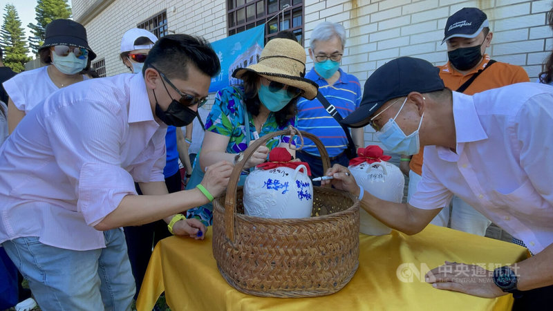 台灣大學後EMBA專班「台大E勢泮」第2屆B班同學與眷屬5日搭機到金門旅遊,一起埋下2罈高粱酒,埋酒前先在酒罈上簽名留念,相約10年後再開罈共飲。(飲酒過量有礙健康;未成年請勿飲酒;酒後勿開車)中央社記者黃慧敏攝 111年8月5日