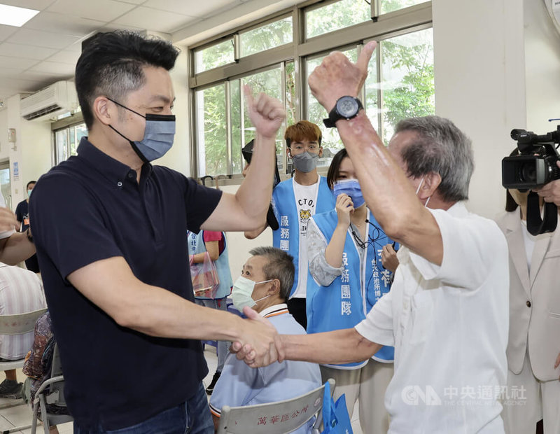 國民黨台北市長參選人蔣萬安(左)5日出席萬華區華江里父親節活動,與現場長輩互動,爭取支持。中央社記者張皓安攝 111年8月5日