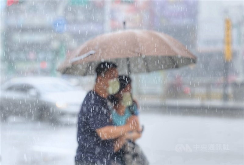 氣象專家吳德榮說，8日起大氣轉趨不穩定，要留意降雨。圖為台北市古亭街頭民眾在大雨中撐傘前行。（中央社檔案照片）