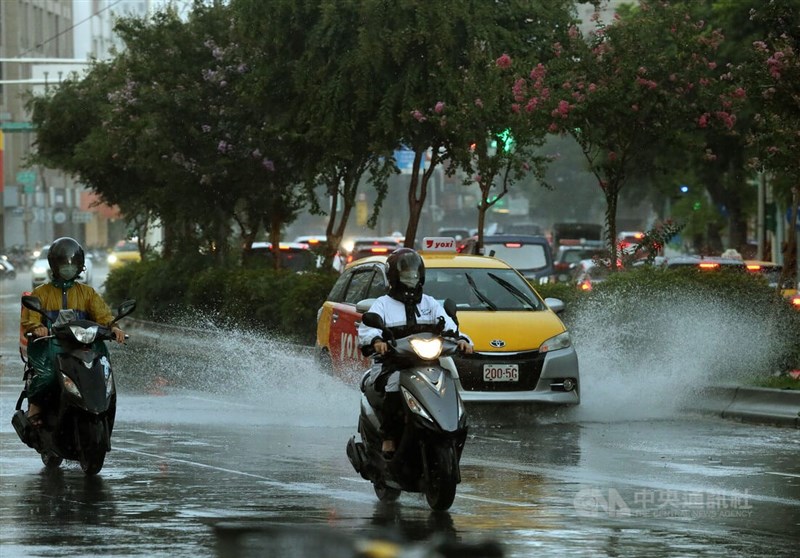 中央氣象局7日針對12縣市發布大雨特報。圖為台北市南區下午降雨，汽機車行經積水路面激起水花。（中央社檔案照片）