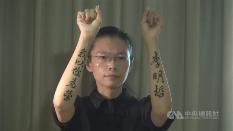 李凈瑜舉起雙臂秀出「李明哲，我以你為榮」刺青，表現對李明哲的支持。（中央社檔案照片）