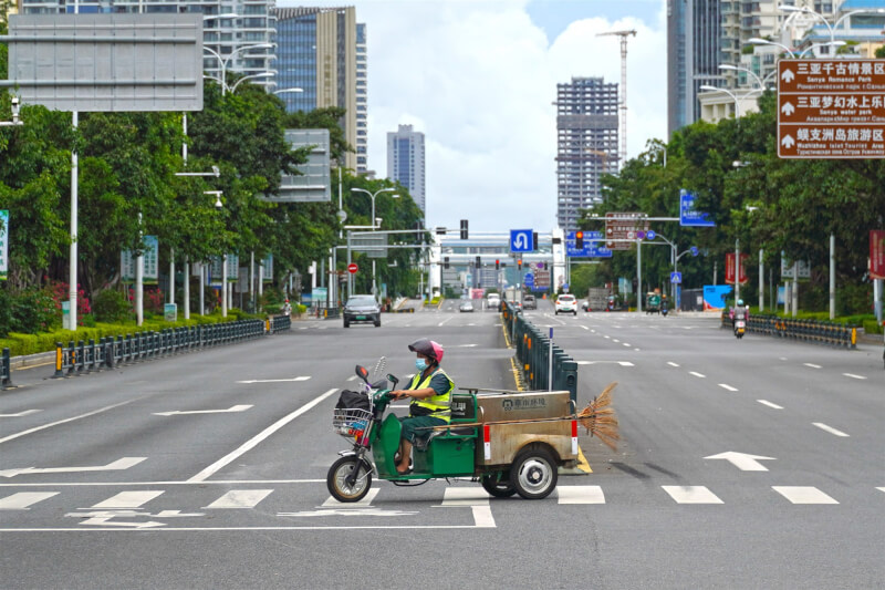 海南省官方宣布，12日前實現社會面清零。圖為6日一名清潔人員駕車駛過迎賓路與三亞灣路路口。（中新社）