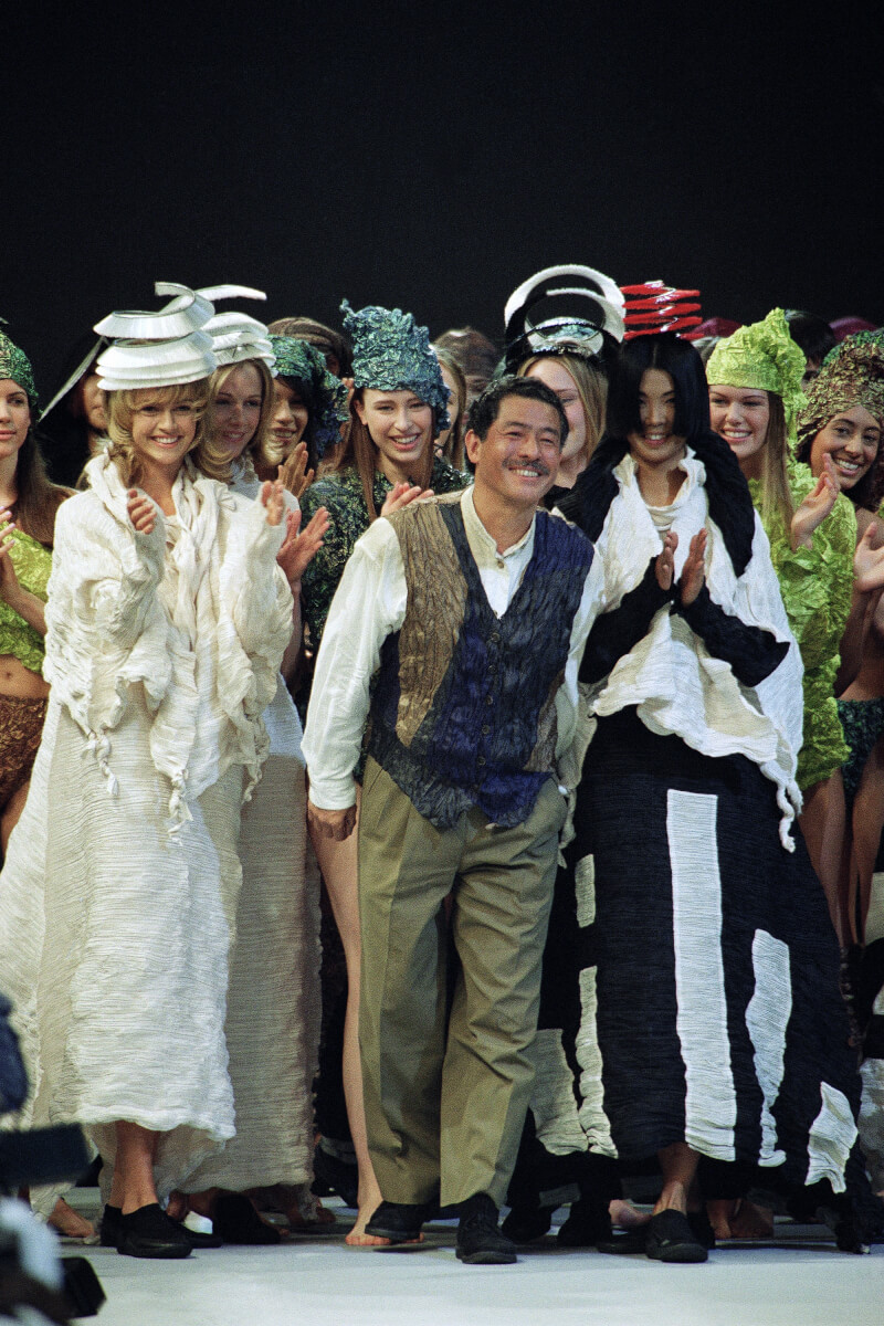 三宅一生1993年3月17日在法國巴黎舉行的秋冬時裝秀後，站在模特兒中間微笑並鞠躬。（美聯社）