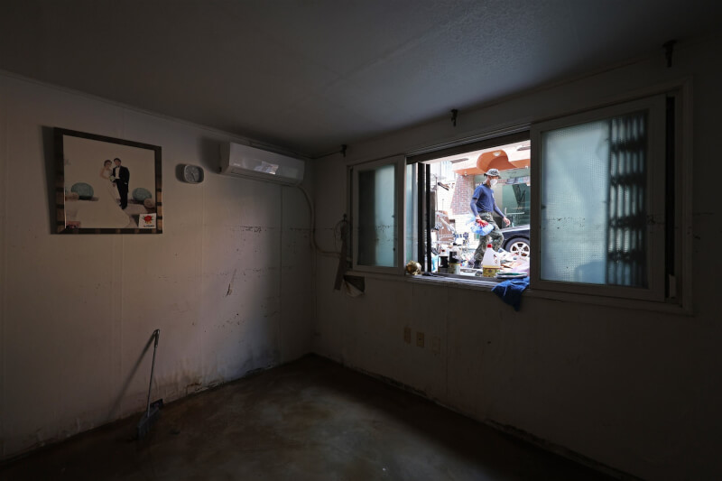 圖為首爾半地下房，連日大雨造成屋內淹水，12日相關人員清理房屋。（韓聯社）