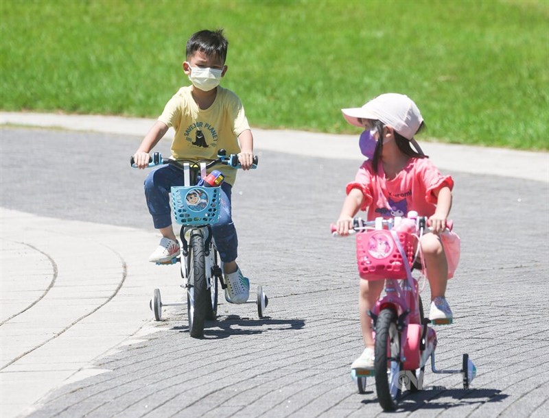 圖為9日中午北市花博公園內小朋友在豔陽下騎腳踏車。（中央社檔案照片）