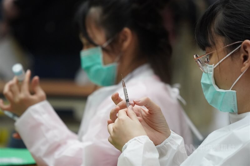 圖為去年12月台北車站疫苗接種站醫護人員以針筒抽取疫苗。（中央社檔案照片）