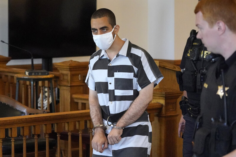 企圖刺殺作家魯西迪的24歲凶嫌馬塔（左）身穿黑白連身衣、戴著白色口罩出庭。（美聯社）
