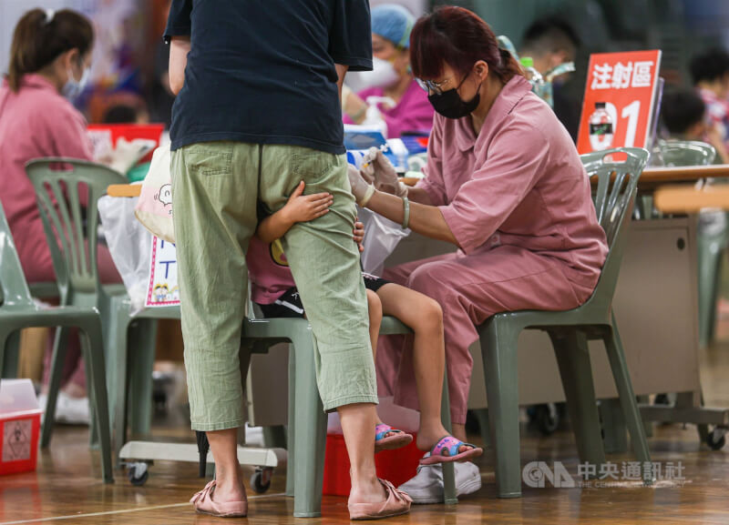 台北市幸安國小2日開放讓學童施打第2劑莫德納與BNT疫苗，有孩子在接種疫苗時一度害怕，緊緊抱著大人。中央社記者鄭清元攝 111年7月2日