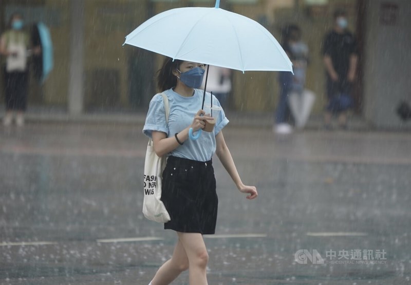 中央氣象局16日下午針對13縣市發布大雨特報。台北市中山區下起午後雷陣雨，民眾撐傘過馬路。中央社記者徐肇昌攝 111年8月16日