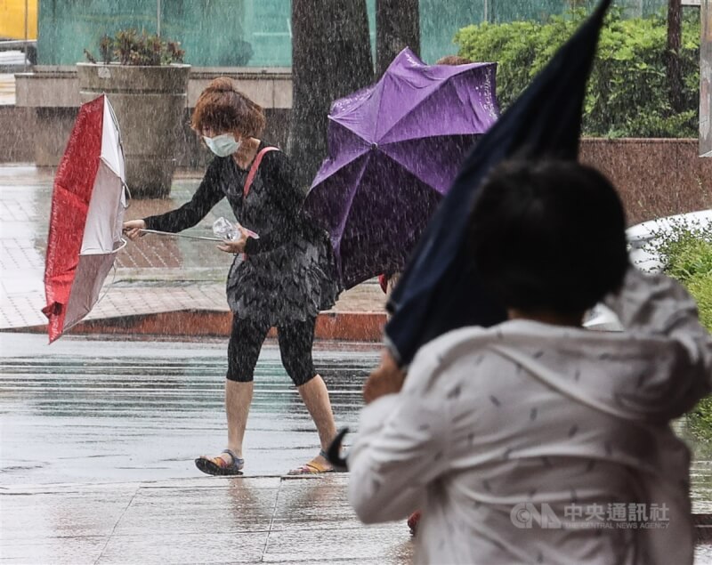 圖為去年7月24日受颱風烟花外圍環流影響，風勢強勁，台北市民眾的傘「開花」變形。（中央社檔案照片）