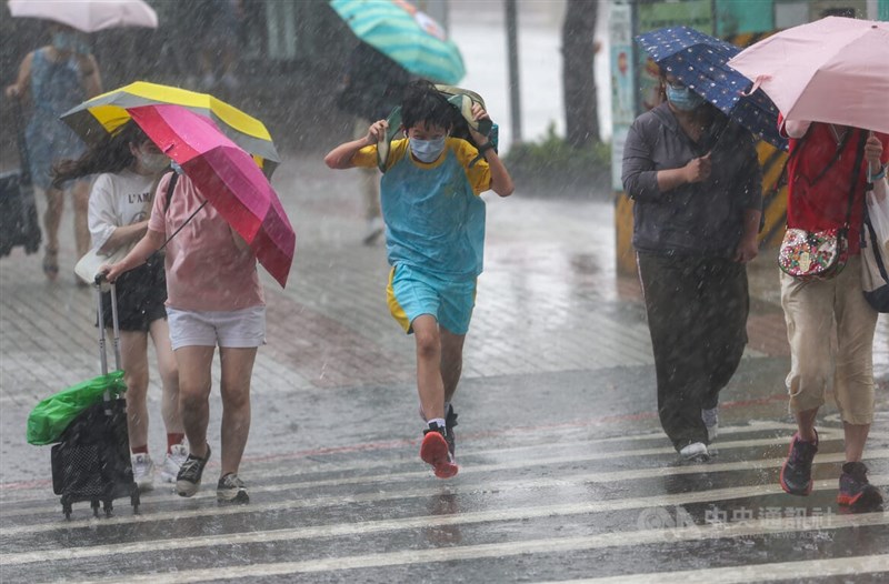 今年8月已至中旬，台灣卻未發過颱風警報。圖為台北市中山區中午下起大雨，有學生未攜帶雨具快步過街。（中央社檔案照片）