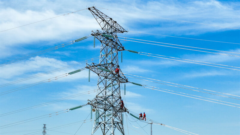 中國近期用電量大增，四川供電商已發通報，若無法緩解供電壓力，只好民生限電。圖為四川電力工人於電塔上施工。（中新社）