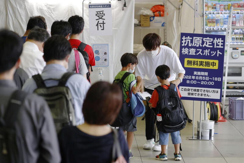 日本正遭受第7波COVID-19疫情侵襲，17日全境至少有15地新增病例再創當地單日新高。圖為民眾於JR新大阪站排隊等候篩檢。（共同社）