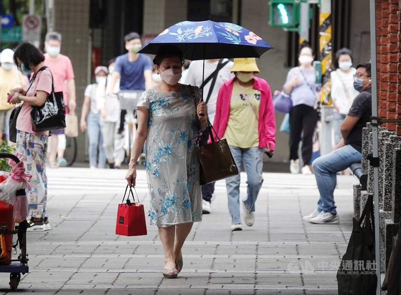 中央氣象局表示，18日午後受熱力作用，留意會有大雨等級雷陣雨。圖為17日民眾在台北市中正區街頭戴帽子、撐傘防曬。（中央社檔案照片）