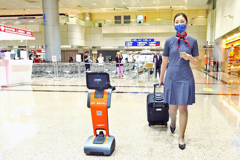 台灣有租車集團業者在疫情爆發後，投入發展AI人工智慧機器人，耗時800多天、斥資新台幣千萬元經費，終於研發出最多可提供10種語言介面、感應周遭變化並避讓，以及發出語音提醒旅客的國門迎賓大使機器人小Fa及小Me（左），18日起展開測試，旅客可透過機器人小Me帶路前往搭車。中央社記者吳睿騏桃園機場攝  111年8月18日