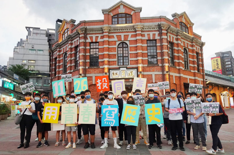 台灣青年民主協會18日晚間與30多名高中職學生在台北西門紅樓前舉辦快閃活動，透過街頭舉牌、街訪及光繪等，號召全台灣民眾11月26日投票日，一起為18歲公民權案投下同意票。（青民協提供）中央社記者陳至中傳真  111年8月18日