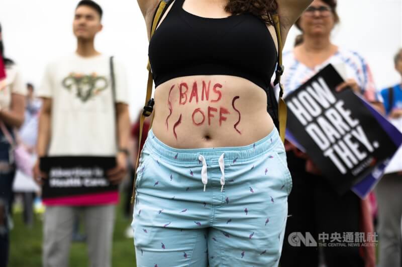 圖為一名示威女子反對最高法院推翻保障婦女墮胎權的羅訴韋德案，在肚皮上寫著禁令滾開的標語。（中央社檔案照片）